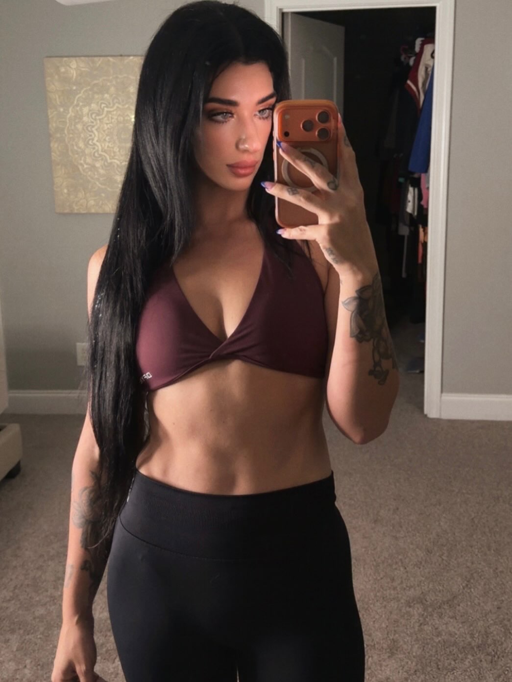 Ally in a burgundy sports bra and black leggings